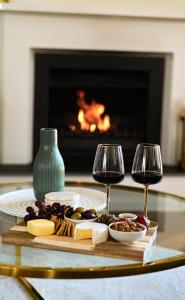 a tray of cheese and wine glasses on a table with a fireplace at Mount Bold Estate - Luxurious Private Retreat in Kangarilla