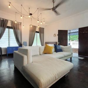 a living room with a large white couch and a chandelier at TG103a Pet Friendly 15pax, near beach side in Tanjung Bungah