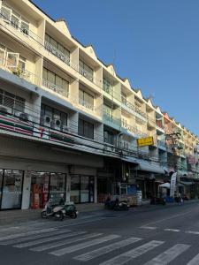 an apartment building with motorcycles parked in front of it at Sleep At Home - Don Mueang in Ban Ko