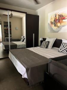 a bedroom with two beds and a painting on the wall at Grand Baie Domaine des Alizées Club & Spa in Grand Baie