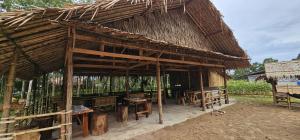 a straw hut with a table and chairs in it at Farm Bungalow in Ao Nam Mao