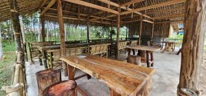 a pavilion with wooden tables and benches in a field at Farm Bungalow in Ao Nam Mao