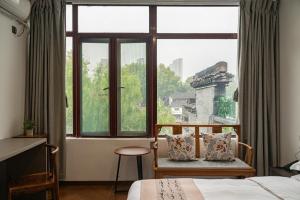 a bedroom with a bed and a large window at Riverside Inn HANGZHOU in Hangzhou