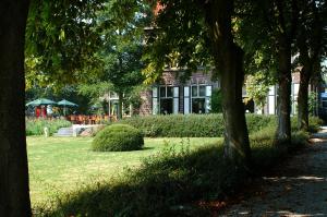 a park with trees in front of a building at Hotel Huys ter Schelde in Koudekerke