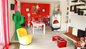 a living room with red walls and a table and chairs at Ciliegissima in Pecetto