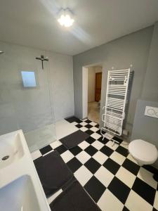 a bathroom with a black and white checkered floor at PAUSE NATURE SORBAIS gîte 2 personnes avec grand SPA privatif, STREAMING et arrivée autonome in Sorbais