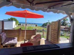 CapesterreにあるKaZa Labat by La Manoshraの赤いパラソルと椅子が備わるパティオ +13枚の写真