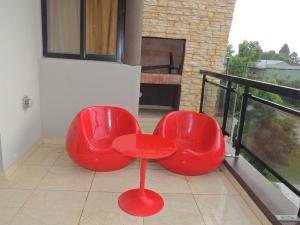 two red chairs sitting on top of a balcony at Apartamento Brisas del Golf in Colón