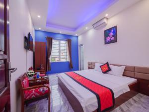 a blue and white bedroom with a bed and a window at TITANIC 3 HOTEL in Hậu Dương