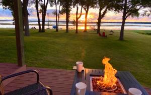 a fire pit sitting on a picnic table with a view of the beach at Leech Lake Resort Bed & Breakfast in Walker