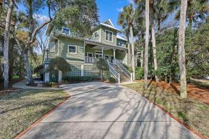 a green house with a tree lined driveway at AB15: 15 Atlantic Beach in Kiawah Island