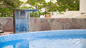 a swimming pool with a water fountain at Vitalclass Lanzarote Resort in Costa Teguise