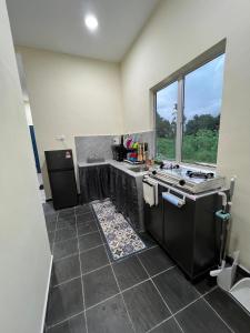 a kitchen with a sink and a stove at Teratak Manis Homestay in Kuantan
