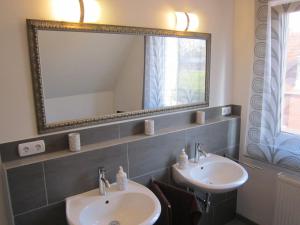 a bathroom with two sinks and a large mirror at Gästehaus Am Linus in Lingen