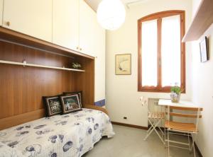 1 dormitorio con cama, mesa y ventana en Tiepolo, en Venecia