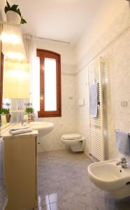 een witte badkamer met 2 wastafels en een toilet bij Tiepolo in Venetië