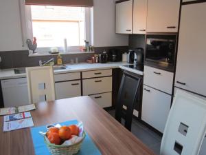 eine Küche mit einer Schale Obst auf einem Tisch in der Unterkunft Gästehaus Am Linus in Lingen
