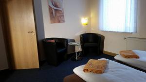 pokój hotelowy z 2 łóżkami i 2 krzesłami w obiekcie Pension Borna w mieście Borna