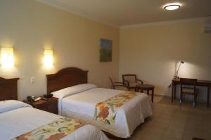 ein Hotelzimmer mit zwei Betten und einem Schreibtisch in der Unterkunft Hotel Argento in Cuernavaca