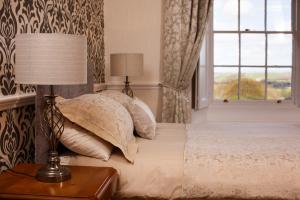a bedroom with a bed with a lamp and a window at Portclew House in Pembroke +21 photos