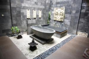 a bathroom with a large tub in a room at Villa Hyarta E1 by Anvia Jogja in Yogyakarta
