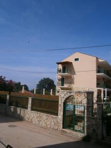 a building with a gate in front of a fence at Petros Studios in Póros Kefalonias