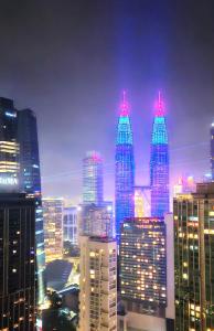 un groupe de grands immeubles dans une ville la nuit dans l'établissement 8 Kia Peng Suites KLCC by Luna, à Kuala Lumpur