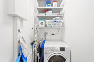 ノルトダイヒにあるAm-Nordmeerstrandの洗濯機と乾燥機を備えたランドリールーム