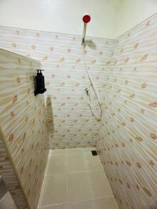 a bathroom with a shower with a red shower head at Navy Guesthouse in Ban Laem Sai