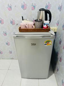 a white refrigerator with a basket on top of it at Navy Guesthouse in Ban Laem Sai +17 photos