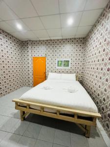 a bedroom with a bed in a room with a wall at Navy Guesthouse in Ban Laem Sai
