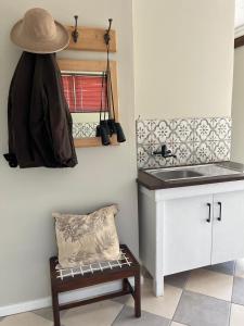 a kitchen with a sink and a hat on the wall at Carneddie cottage-garden in Bredasdorp