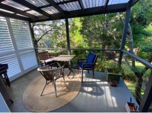 un porche cubierto con mesa y sillas en Maisie's Cottage, en Mount Victoria