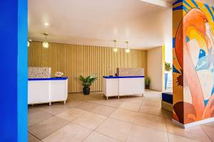 a lobby with two reception desks and a painting at TRYP by Wyndham Aruba in Palm-Eagle Beach
