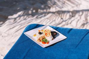 a white plate with food on a blue napkin at TRYP by Wyndham Aruba in Palm-Eagle Beach