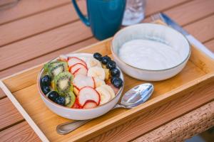 a tray with a bowl of fruit and a bowl of dip at TRYP by Wyndham Aruba in Palm-Eagle Beach