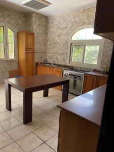 eine Küche mit einem Tisch in der Mitte in der Unterkunft Shorouk Mansion in Madīnat ash Shurūq