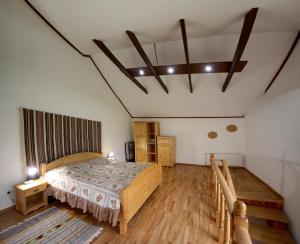 ein Schlafzimmer mit einem großen Bett und Holzböden in der Unterkunft Villa Roksolana in Truskawez