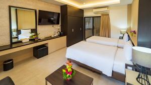a hotel room with a large bed and a table at Nongnooch Garden Pattaya Resort in Ban Nong Chap Tao +8 photos