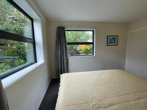 a bedroom with a bed and two windows at Character & new CNZhouse with quiet in Christchurch