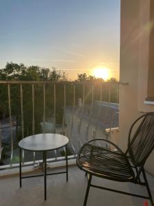 Ein Tisch und Stühle auf einem Balkon mit Blick auf den Sonnenuntergang in der Unterkunft ApartNaest Radeberg - vollausgestattete 1 - bis 4-Zimmer Apartments l 24h Zugang per Code l Check-in Anleitung über Posteingang l Parkplatz auf Anfrage l Frühstück optional in Radeberg