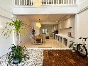 an open kitchen and dining room with a table and plants at PANI Place Khaolak in Khao Lak