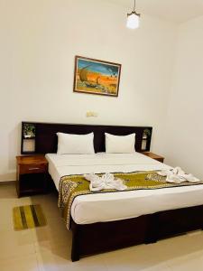 a bedroom with a large bed with white sheets at Sakura Villa Hikkaduwa in Hikkaduwa