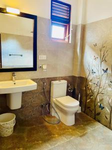a bathroom with a toilet and a sink at Sakura Villa Hikkaduwa in Hikkaduwa +43 photos