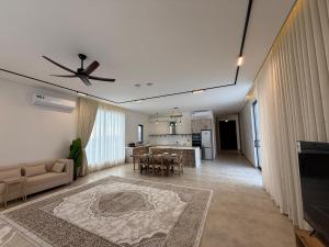 a living room with a ceiling fan and a kitchen at The Balance Retreat in Būbādī
