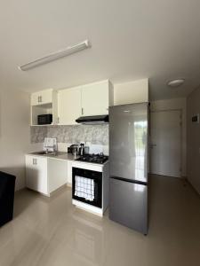 a kitchen with a stainless steel refrigerator and white cabinets at Millennial Minimalist haven in Durban