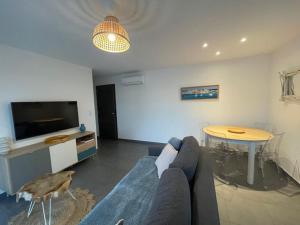 a living room with a blue couch and a table at Appart 2 chambres Proche Port de Porto Vecchio in Porto-Vecchio