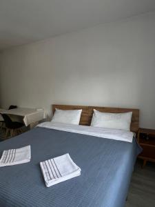 Un dormitorio con una cama con toallas. en Bayir Studio Apartment, en Karakol