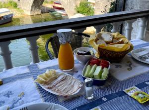 a table with a plate of food and a bottle of juice at Rooms Milena in Rijeka Crnojevića