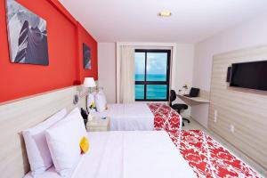 Habitación de hotel con 2 camas y TV de pantalla plana. en Comfort Hotel & Suites Natal, en Natal